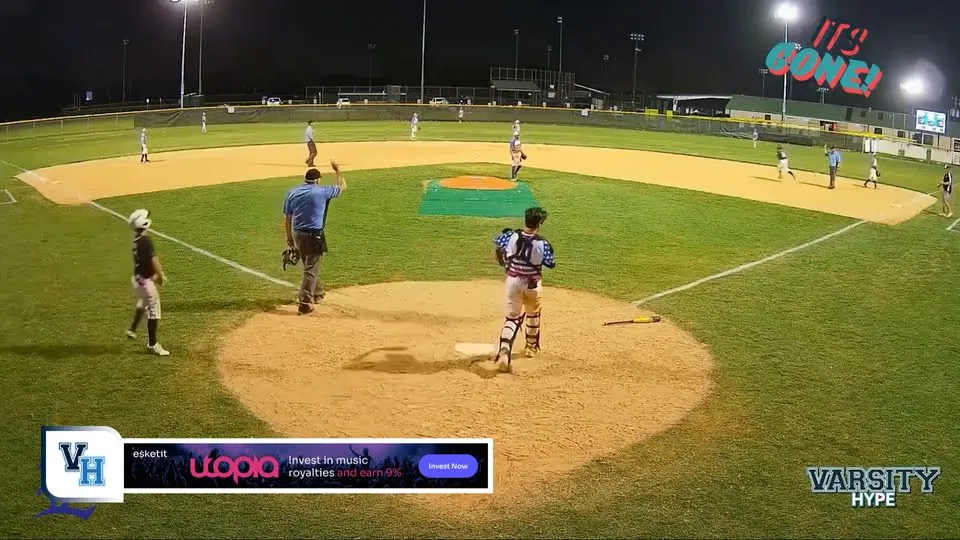 A baseball field at night with a lower-third banner ad below the action