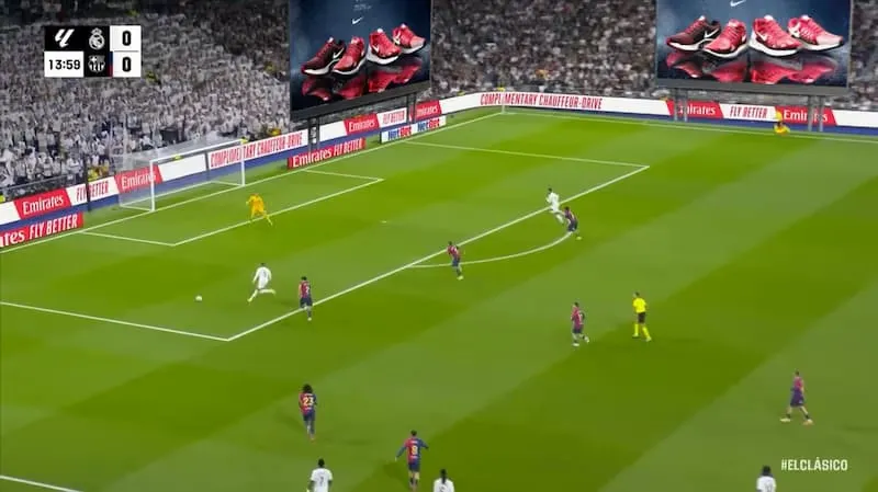 Wide shot of a Clásico match with programmatic ads on the stadium's giant screens